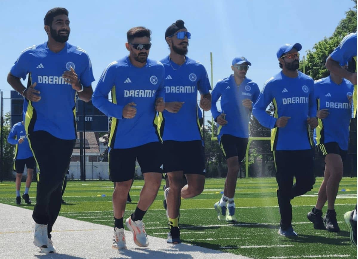 Indian cricket team members jogging on a field during a training session, all wearing blue training kits with 'Dream11' branding.