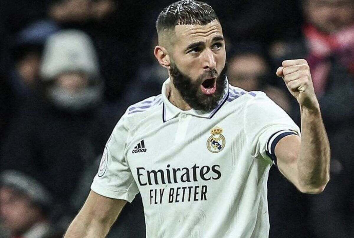 Karim Benzema, wearing a Real Madrid jersey, celebrates with a fist pump during a game.