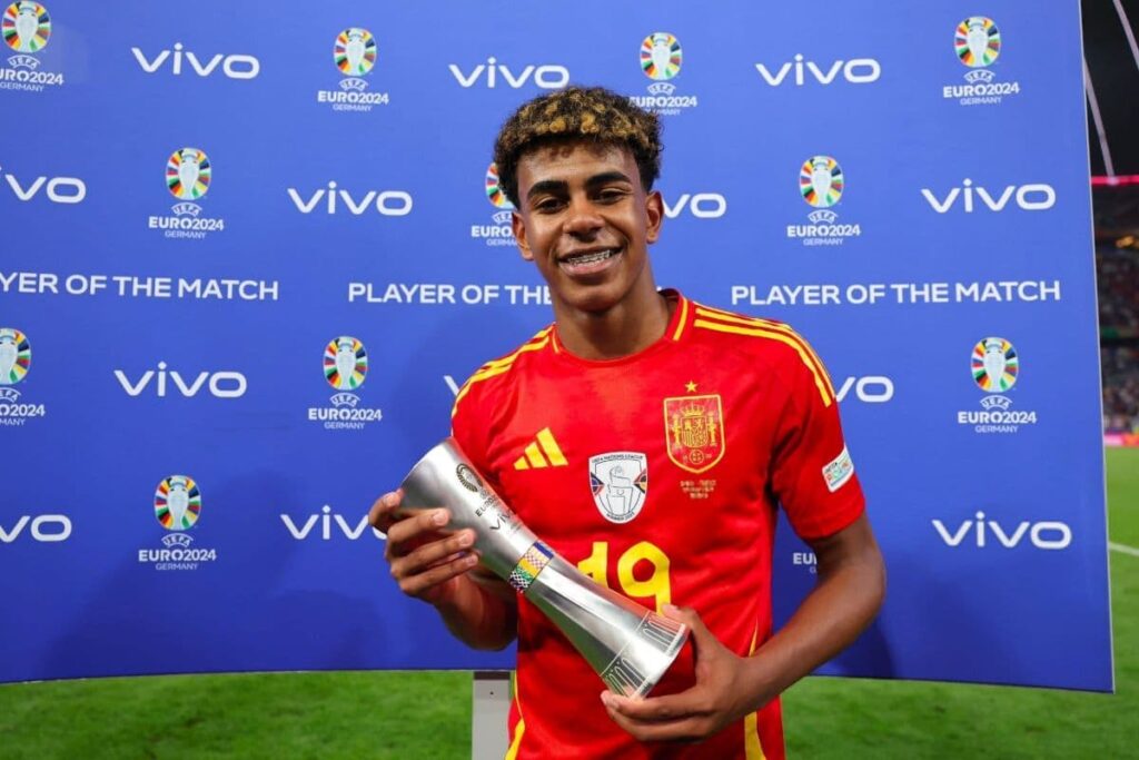 Lamine Yamal holding the Player of the Match trophy in a Spain jersey at Euro 2024.